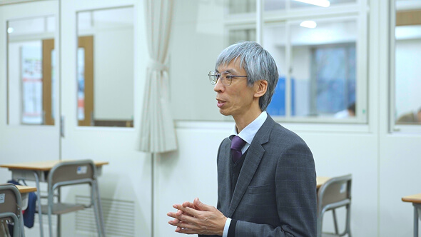 教室で教諭が説明をしている様子