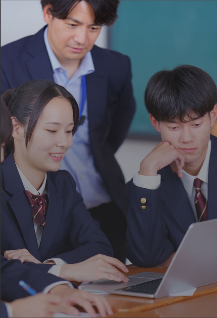 ノートパソコンを操作しながら高校生が教室で勉強している様子